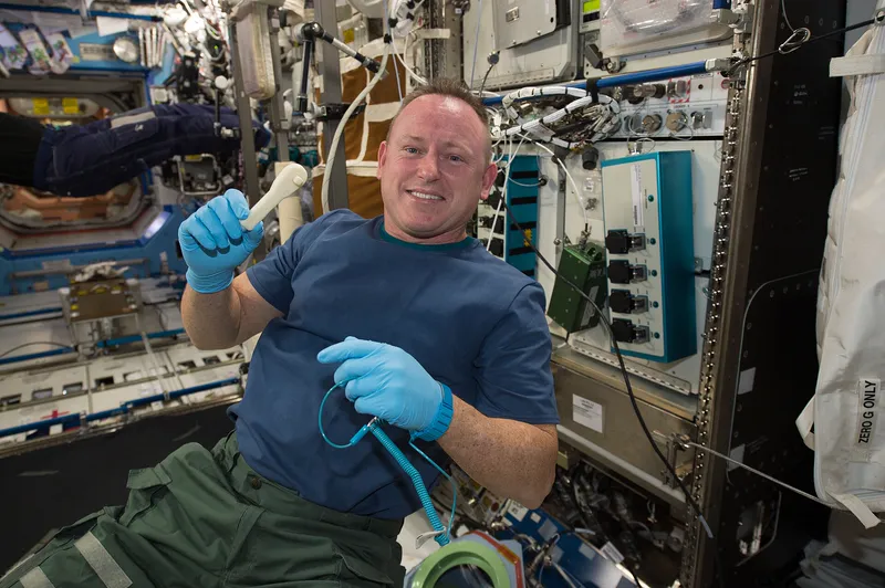 Astronaut Barry Wilmore holding a ratchet wrench 3D printed on the space station from a design sent from Earth.
