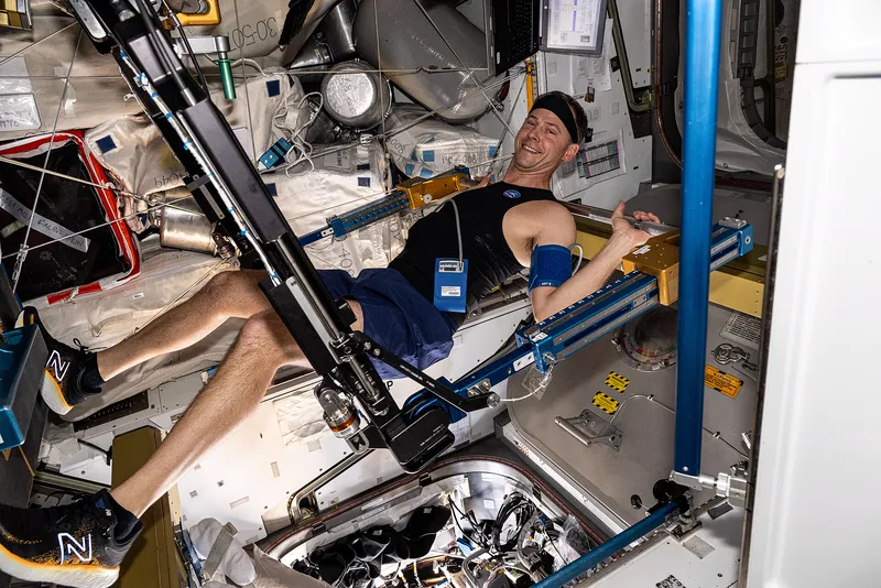 An astronaut exercising on the space station to protect bones and muscles.