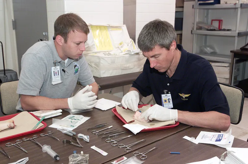 Astronauts practicing medical skills before a long mission.