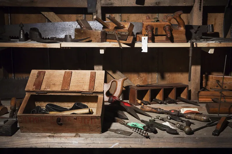 A 19th-century woodworker's bench with many hand tools.