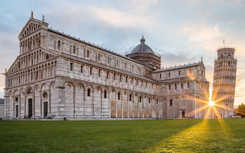 The cathedral and the leaning bell tower of Pisa, Italy, at sunrise.