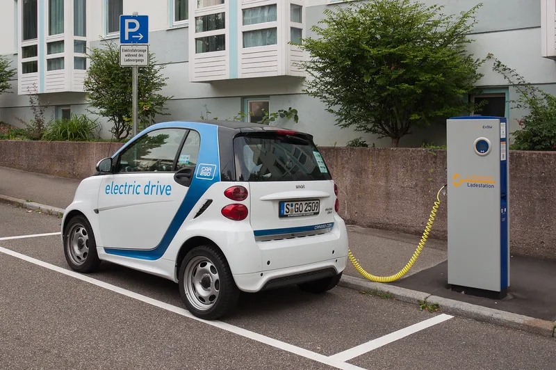 A small electric car charging at a public charging point in Stuttgart, Germany.