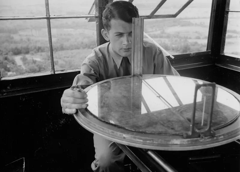 A lookout sighting a fire with an Osborne Fire Finder (historical photograph).