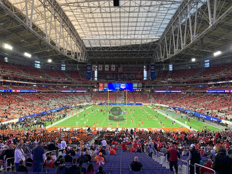 A packed stadium bowl, with seats rising steeply around the field.