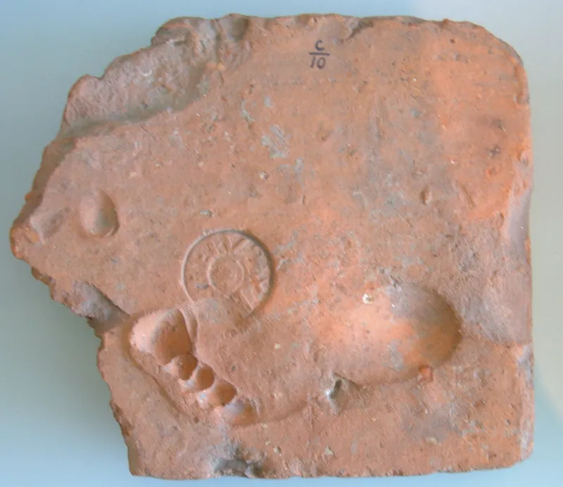 A Roman clay tile with a maker's stamp and the footprints of an animal that walked on it while it was drying.