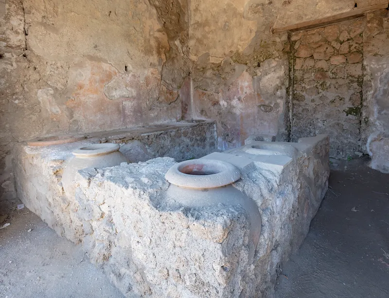 A serving counter with built-in jars in Pompeii, where travelers and locals bought food and drink.