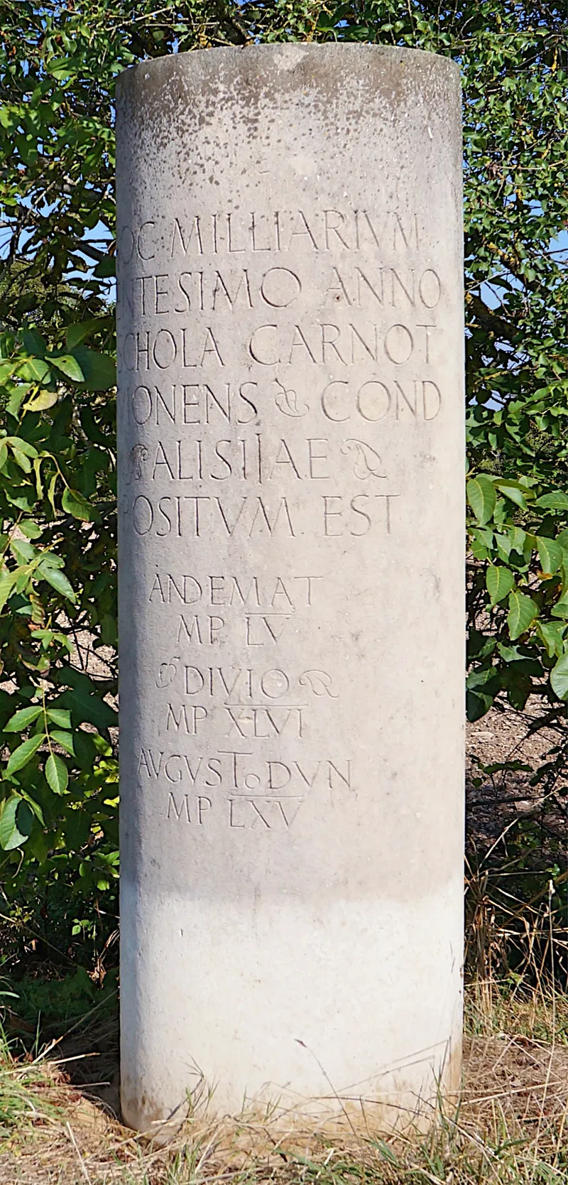 A replica Roman milestone, carved with distance information.