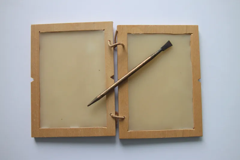 A modern replica of a Roman wax writing tablet with a stylus.