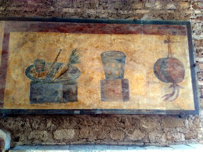 A painted sign in Ostia showing food and drink for sale.